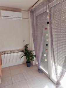 a room with a window with a curtain and a plant at Studio Concept Apartment in Zagreb