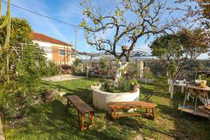 un patio con dos bancos y una mesa y un árbol en Nuvola Verde en Antipernoí