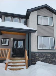 a house with a black door and snow on the porch at House of Love in Winnipeg