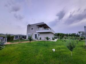 a large white house in a field of grass at HILLTOP HIDEAWAY in Elbasan