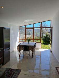 ein Esszimmer mit einem Tisch und einem großen Fenster in der Unterkunft Chalet do Médico in Rodeiro