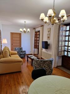 ein Wohnzimmer mit einem Sofa, Stühlen und einem TV in der Unterkunft Chalet do Médico in Rodeiro