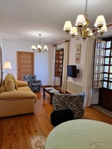 a living room with a couch and chairs and a tv at Chalet do Médico in Rodeiro