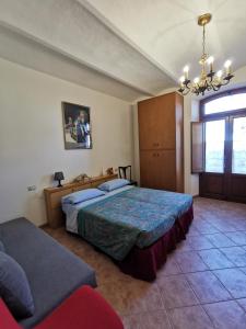 a bedroom with two beds and a chandelier at Le Frasche di Marido holiday apartments in Alberese