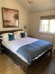 a bedroom with a large bed with a blue blanket at Pear Tree Cabin in Beaulieu