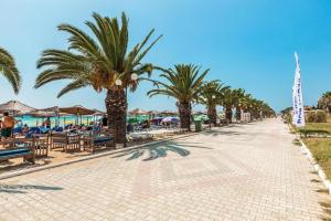 brukowana ulica z palmami i plażą w obiekcie Pashalina w mieście Nea Plagia