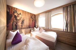 Zimmer mit 3 Betten und Wandgemälde in der Unterkunft Gerlosperle in Gerlos