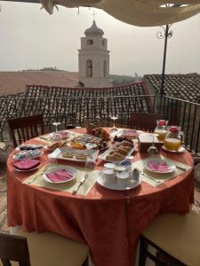 una mesa con platos de comida en ella con una torre en Palazzo dei Poeti, en Tursi