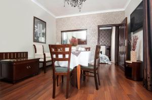uma sala de jantar com uma mesa branca e cadeiras em Titanic em Bialystok