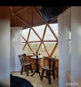 a room with a table and two chairs in front of a window at Glamping y Cabañas el Encanto- los novios in Tota