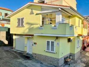 Una casa amarilla con una escalera. en B&B Mare Monti Miniere, en Iglesias