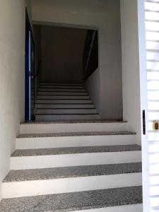 un escalier menant à une porte bleue dans l'établissement Casa nova com suítes amplas, à Ouro Preto