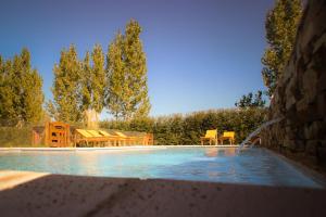 Una piscina con una mesa y sillas al lado. en Altos la Villa, en San Rafael