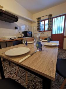 una mesa de madera con platos y vasos. en Family apartment with 2 bedrooms to the city center, en Kamena Vourla