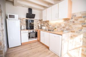 a kitchen with white cabinets and a white refrigerator at Appt Ambiance Chalet 2ch Piscine lagon in Tarbes