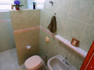 a bathroom with a toilet and a sink at Casa à Beira-Mar com Churrasqueira, TV e Wi-fi in Balneário Praia do Leste