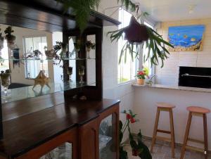 a kitchen with a counter and stools in a room at Casa com Vista Panorâmica da Praia de Pontal do PR in Balneário Praia do Leste