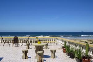 a table and chairs on a patio near the beach at Casa com Vista Panorâmica da Praia de Pontal do PR in Balneário Praia do Leste