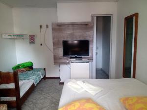 a bedroom with two beds and a flat screen tv at Mare Mar in Tramandaí
