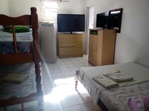 a bedroom with a bed and a tv and a televisionictericter at Mare Mar in Tramandaí
