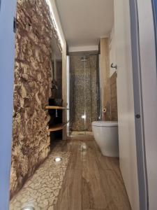 a bathroom with a white tub and a stone wall at Tiny Circe house - alloggio turistico in San Felice Circeo