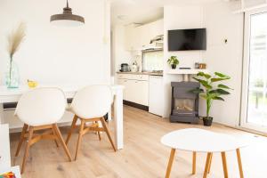 cocina con mesa, 2 sillas y chimenea en Chalet 't zeeuwse genot, en Baarland