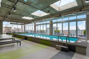 a large swimming pool in a building with windows at Jeffjack Heated Pool Penthouse in Chicago's West Loop in Chicago