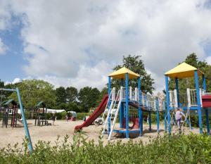 un parque infantil con un tobogán en la arena en Chalet 't zeeuwse genot en Baarland