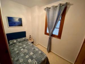 1 dormitorio con cama y ventana en Blue Corredera Vejer, en Vejer de la Frontera