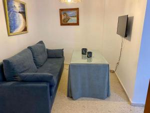 sala de estar con sofá azul y mesa en Blue Corredera Vejer, en Vejer de la Frontera