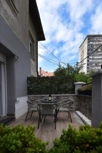 a patio with a table and chairs on a balcony at TASOS in Belgrade