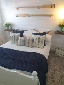 een bed met blauwe en witte lakens en kussens bij Boutique Coastal appt nr Edinburgh in Saint Davids