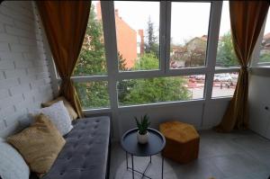 a living room with a couch and large windows at Mariposa in Smederevo