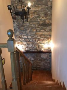 uma escadaria com uma parede de pedra e um lustre em Pensión Xacobe em Cabreiros