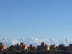 um grupo de edifícios com montanhas ao fundo em VILLA Garden em Marrakech