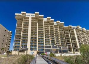 a large building on the beach with a blue sky at Phoenix 1 Unit 1101 in Orange Beach