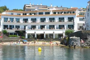 a large body of water with buildings and people at Hotel Playa Sol in Cadaqués