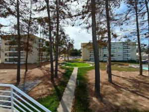 een pad door een park met bomen en gebouwen bij Hermoso Dpto entre bosque y piscina. in El Tabo