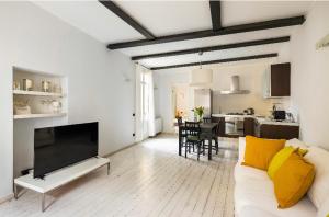 een woonkamer met een witte bank en een televisie bij Casa la Breva in Lecco