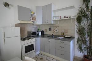 cocina blanca con fogones y nevera en Maddalena House, en Spello