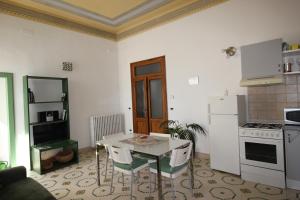 a kitchen with a table with chairs and a refrigerator at Maddalena House in Spello