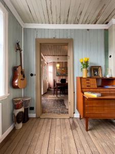 een kamer met een piano en een gitaar in een kamer bij The Old Bookstore in Flateyri