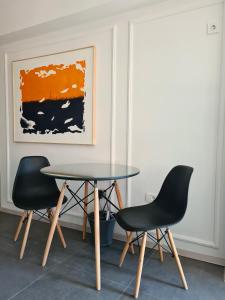 uma mesa e duas cadeiras numa sala com um quadro em MIKA Premium em Skopje