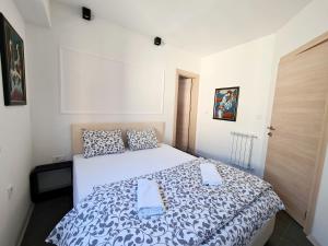 um quarto com uma cama branca e um edredão preto e branco em MIKA Premium em Skopje
