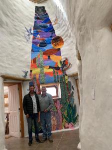 two men are standing in front of a mural at Ecodomos La Tongoycilla in Guanaqueros