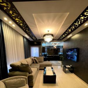 アンマンにあるAlghalayieny Modern Apartmentsのソファとシャンデリアのあるリビングルーム