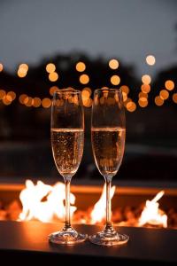 two glasses of champagne sitting on a table with a fireplace at *NEW* The Palm Garden - Bright, Tropical Retreat! in Palm Beach Gardens