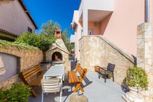 a patio with chairs and a table and a fireplace at Apartments Lemmy in Zadar