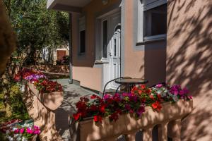a balcony with flowers and a table and a window at Apartments Lemmy in Zadar +2 photos