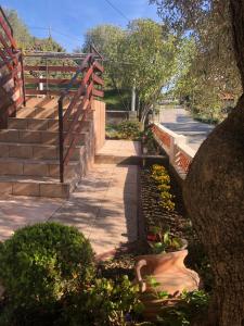 een tuin met bloemen en een hek en trappen bij Apartmani Anamar in Supetarska Draga